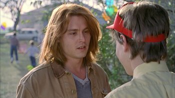 Movie still from “What's Eating Gilbert Grape” (1993), directed by Lasse Hallström – Two young men talking to each other in a park setting; Close Up shot, Over the shoulder angle