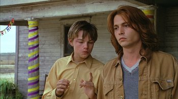 Movie still from “What's Eating Gilbert Grape” (1993), directed by Lasse Hallström – Two young men standing next to each other in front of a house; Close Up shot, Low angle