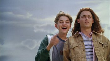 Movie still from “What's Eating Gilbert Grape” (1993), directed by Lasse Hallström – Two young men standing next to each other on a cloudy day; Close Up shot, Low angle