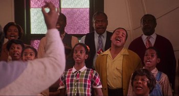 Movie still from “What's Love Got to Do with It” (1993), directed by Brian Gibson – A group of men and women singing in a church; Medium shot, Low angle