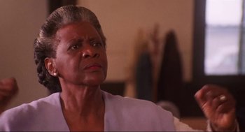 Movie still from “What's Love Got to Do with It” (1993), directed by Brian Gibson – An older woman looking up at the ceiling; Close Up shot, Low angle