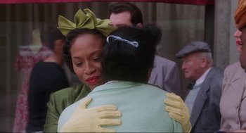 Movie still from “What's Love Got to Do with It” (1993), directed by Brian Gibson – A woman in a green dress hugging another woman in a green dress; Medium shot, Over the shoulder angle