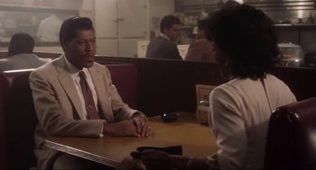 Movie still from “What's Love Got to Do with It” (1993), directed by Brian Gibson – A man and a woman sitting at a table in a restaurant; Medium shot, Over the shoulder angle