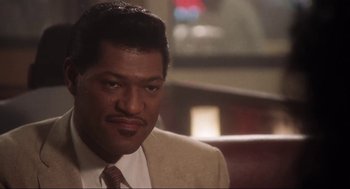 Movie still from “What's Love Got to Do with It” (1993), directed by Brian Gibson – A person wearing a suit and tie; Close Up shot, Low angle