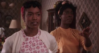 Movie still from “What's Love Got to Do with It” (1993), directed by Brian Gibson – Two women standing next to each other in front of a table; Close Up shot, Over the shoulder angle