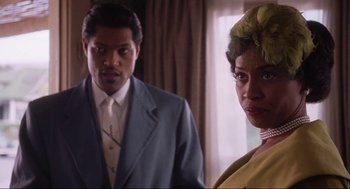 Movie still from “What's Love Got to Do with It” (1993), directed by Brian Gibson – A man and a woman standing next to each other in a room; Close Up shot, Over the shoulder angle