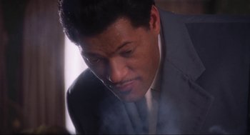 Movie still from “What's Love Got to Do with It” (1993), directed by Brian Gibson – A person wearing a suit and tie; Close Up shot, Low angle