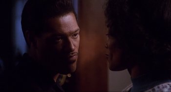 Movie still from “What's Love Got to Do with It” (1993), directed by Brian Gibson – A man and a woman face to face in a dark room; Close Up shot, Over the shoulder angle