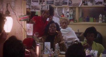 Movie still from “What's Love Got to Do with It” (1993), directed by Brian Gibson – Three women are sitting at a table in front of a mirror; Medium shot, Over the shoulder angle
