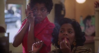Movie still from “What's Love Got to Do with It” (1993), directed by Brian Gibson – Two women smoking and one is holding a cigarette holder; Close Up shot, Low angle