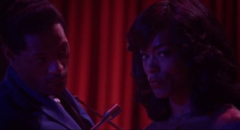 Movie still from “What's Love Got to Do with It” (1993), directed by Brian Gibson – A man and a woman are standing in front of microphones; Close Up shot, Over the shoulder angle