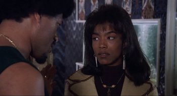 Movie still from “What's Love Got to Do with It” (1993), directed by Brian Gibson – A woman with long black hair wearing a brown jacket; Close Up shot, Over the shoulder angle