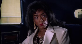 Movie still from “What's Love Got to Do with It” (1993), directed by Brian Gibson – A woman with long black hair wearing a white jacket; Close Up shot, Low angle