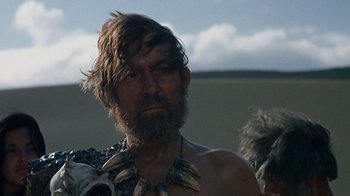 Movie still from “When Dinosaurs Ruled the Earth” (1970), directed by Val Guest – A person wearing a necklace; Close Up shot, Low angle