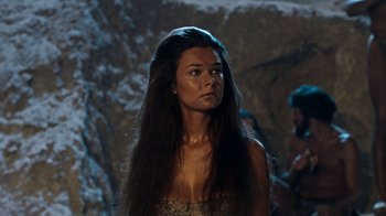 Movie still from “When Dinosaurs Ruled the Earth” (1970), directed by Val Guest – A woman with long black hair standing in a cave; Close Up shot, Over the shoulder angle