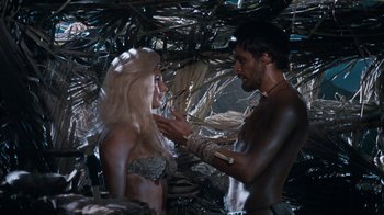 Movie still from “When Dinosaurs Ruled the Earth” (1970), directed by Val Guest – A man and a woman are talking in the jungle; Medium shot, Over the shoulder angle