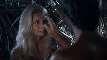 Movie still from “When Dinosaurs Ruled the Earth” (1970), directed by Val Guest – A woman looking into a mirror while a man touches her face; Close Up shot, Over the shoulder angle