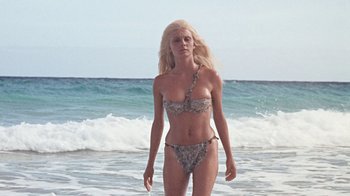 Movie still from “When Dinosaurs Ruled the Earth” (1970), directed by Val Guest – A woman standing in the water at the beach; Medium shot, Low angle
