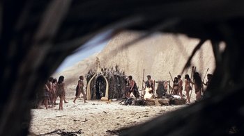 Movie still from “When Dinosaurs Ruled the Earth” (1970), directed by Val Guest – A group of people standing on top of a sandy beach; Extreme Wide shot, High angle