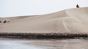 Movie still from “When Dinosaurs Ruled the Earth” (1970), directed by Val Guest – A body of water near a sandy beach; Extreme Wide shot, High angle