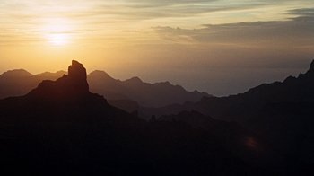 Movie still from “When Dinosaurs Ruled the Earth” (1970), directed by Val Guest – The sun is setting over a mountain range; Extreme Wide shot, Low angle