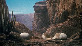Movie still from “When Dinosaurs Ruled the Earth” (1970), directed by Val Guest – An image of an open egg shell in the middle of a rocky area; Extreme Wide shot, Low angle