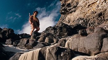 Movie still from “When Dinosaurs Ruled the Earth” (1970), directed by Val Guest – A man is walking up a rocky hill; Wide shot, Low angle