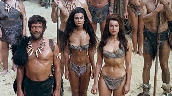 Movie still from “When Dinosaurs Ruled the Earth” (1970), directed by Val Guest – A group of people standing next to each other in animal skins; Wide shot, Low angle