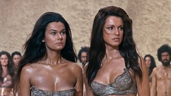 Movie still from “When Dinosaurs Ruled the Earth” (1970), directed by Val Guest – A couple of women standing next to each other; Medium shot, Low angle