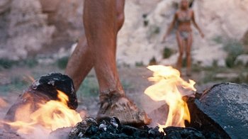Movie still from “When Dinosaurs Ruled the Earth” (1970), directed by Val Guest – A man and a woman walking on a fire; Extreme Close Up shot, Low angle