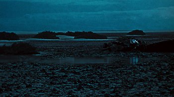 Movie still from “When Dinosaurs Ruled the Earth” (1970), directed by Val Guest – A body of water at night time with dark clouds; Extreme Wide shot, High angle