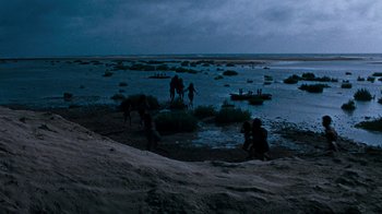 Movie still from “When Dinosaurs Ruled the Earth” (1970), directed by Val Guest – A group of people standing on top of a sandy beach; Extreme Wide shot, High angle