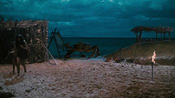 Movie still from “When Dinosaurs Ruled the Earth” (1970), directed by Val Guest – An image of an ocean scene with a crab on the beach at night time; Extreme Wide shot, High angle