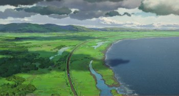 Movie still from “When Marnie Was There” (2014), directed by Hiromasa Yonebayashi – An aerial view of a river with a train on it's side; Extreme Wide shot, High angle