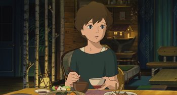 Movie still from “When Marnie Was There” (2014), directed by Hiromasa Yonebayashi – A person sitting at a table with a bowl of food; Medium shot, High angle
