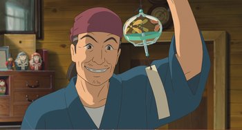 Movie still from “When Marnie Was There” (2014), directed by Hiromasa Yonebayashi – An animated man holding up a toy hanging from the ceiling; Medium shot, Low angle
