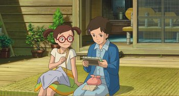 Movie still from “When Marnie Was There” (2014), directed by Hiromasa Yonebayashi – A girl and a boy sitting on the ground; Medium shot, High angle