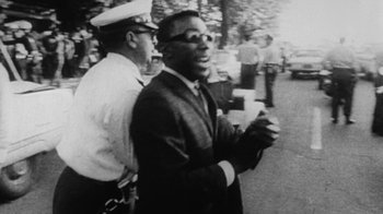 Movie still from “When We Were Kings” (1996), directed by Leon Gast – An old black and white photo of a man in a suit; Medium shot, High angle