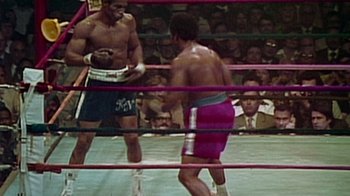 Movie still from “When We Were Kings” (1996), directed by Leon Gast – Two boxers in a boxing ring during a match; Medium shot, High angle