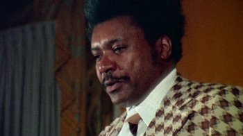 Movie still from “When We Were Kings” (1996), directed by Leon Gast – A person wearing a suit and tie; Close Up shot, Low angle