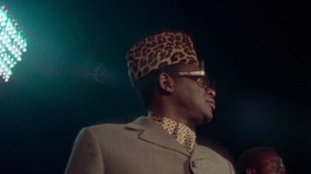 Movie still from “When We Were Kings” (1996), directed by Leon Gast – A man wearing a leopard print hat and a suit; Close Up shot, Low angle