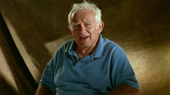 Movie still from “When We Were Kings” (1996), directed by Leon Gast – An older man sitting in a chair with a smile on his face; Close Up shot, Low angle
