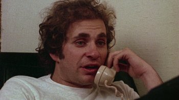 Movie still from “When We Were Kings” (1996), directed by Leon Gast – A man talking on a phone while sitting on a couch; Close Up shot, Low angle