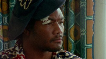 Movie still from “When We Were Kings” (1996), directed by Leon Gast – A person wearing a pirate hat; Close Up shot, Low angle