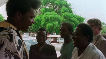 Movie still from “When We Were Kings” (1996), directed by Leon Gast – A group of men standing next to each other; Close Up shot, Low angle
