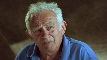 Movie still from “When We Were Kings” (1996), directed by Leon Gast – An older man with white hair wearing a blue shirt; Close Up shot, Over the shoulder angle