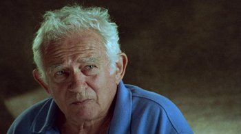 Movie still from “When We Were Kings” (1996), directed by Leon Gast – An older man with white hair wearing a blue shirt; Close Up shot, Low angle