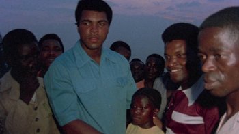 Movie still from “When We Were Kings” (1996), directed by Leon Gast – A group of men standing next to each other in a field; Close Up shot, Low angle
