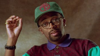 Movie still from “When We Were Kings” (1996), directed by Leon Gast – A person wearing glasses and a hat; Close Up shot, Low angle