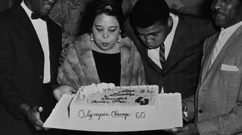 Movie still from “When We Were Kings” (1996), directed by Leon Gast – A man and a woman are looking at a cake; Close Up shot, Low angle